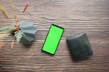 Masada yeşil ekranlı ve cüzdanı olan akıllı telefonun üst görünümü ,