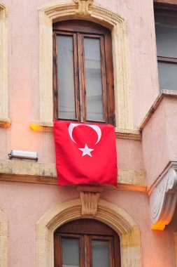 Pencerede Türk bayrağı asılı.
