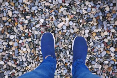 Taş zemindeki erkek ayakkabılarının en üst görüntüsü.