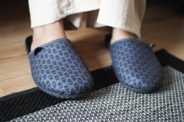 Evde yumuşak terlikli bir kadın var..