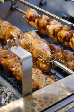Kızarmış tavuklar barbekü ateşinde kızartılıyor..