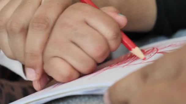 mère aidant son enfant à dessiner sur papier .