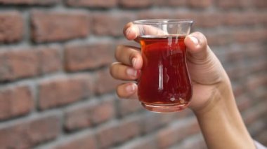 Kadınlar tuğla duvara geleneksel Türk çayı tutuyorlar. ,