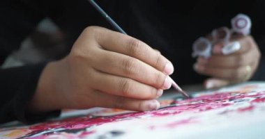 Kadınlar fırçayı boyayla tutarlar. .