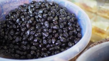 Kavanozda kaşık ile siyah zeytin dilimler.