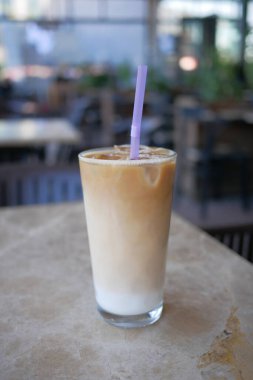 Dışarıdaki kafe masasında şeffaf bir bardakta buzlar eridi. ,