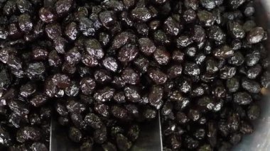 Kavanozda kaşık ile siyah zeytin dilimler.