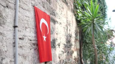 Pencerede Türk bayrağı asılı.