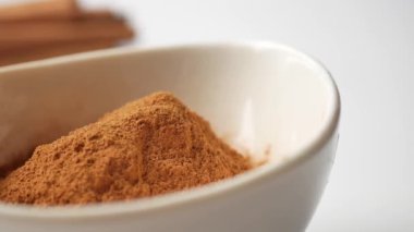 tarçın ve beyaz zemin üzerine toz tarçın