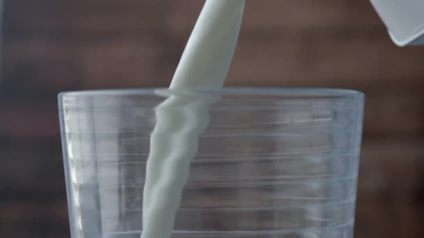 白い新鮮なミルクは透明なガラスに注がれています — ストック動画