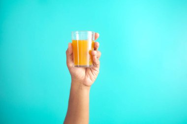 Elinde bir bardak portakal suyu vardı. ,