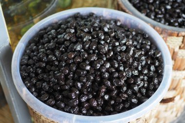 Kavanozda kaşık ile siyah zeytin dilimler.