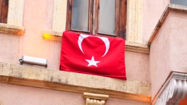 Pencerede Türk bayrağı asılı.