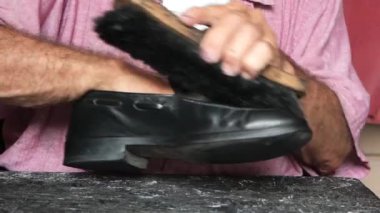 Yerde fırçayla ayakkabı temizliği. .