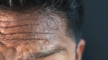 Alnındaki terin koyu arkaplana yakın çekimi 