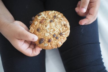  Elinde tatlı kurabiyeler olan çocuk elinin en üst görüntüsü .