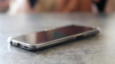 El ele tutuşup masadan cep telefonunu almak.