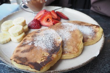 Böğürtlenli lezzetli yemek ve siyah arka planda kremalı kek.,