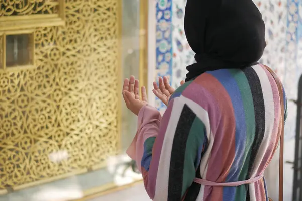 rear view of women praying at mosque .