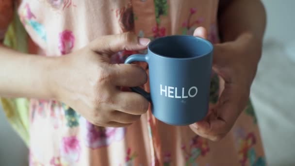 こんにちは単語の青いコーヒー カップを持っている女性 — ストック動画