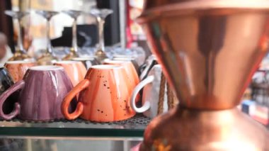 Kafedeki kahve makinesine dizilmiş renkli kahve fincanı. 