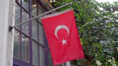 Pencerede Türk bayrağı asılı.