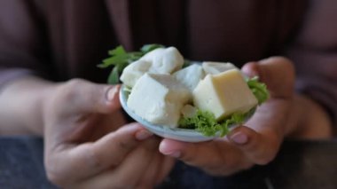 Kadınlar elle küp şeklinde peynir seçer.