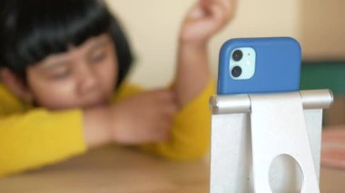 Çocuk kız akıllı telefondan çizgi film izliyor. ,