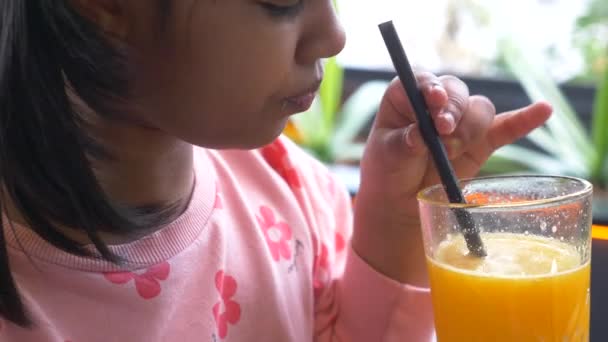 Child Hand Holding Glass Orange Juice — Stock Video