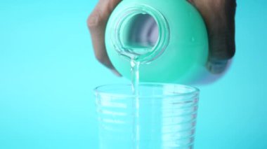 Yeşil renkli bir şişeden akan su ,