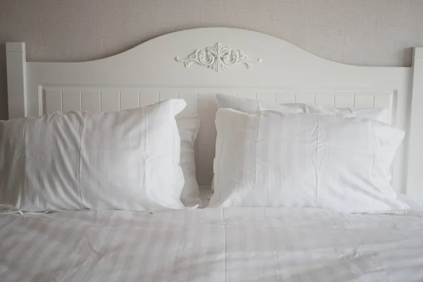 white pillow lined up on bed ,