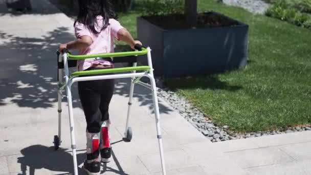 Kind Met Loopframe Knie Orthose Buiten — Stockvideo