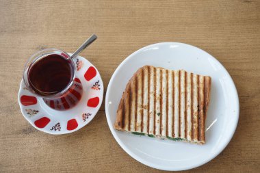 Ekmek tostları beyaz tabakta ve çay .