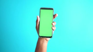 Elinde yeşil ekranlı akıllı bir telefon var. .