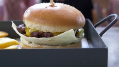 Çizburger ve patates kızartması kafe masasında servis edilir. .