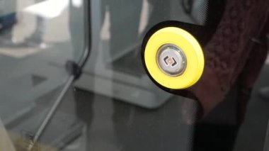 Metro vagonundaki kapıları açmak için parmak düğmesine basar