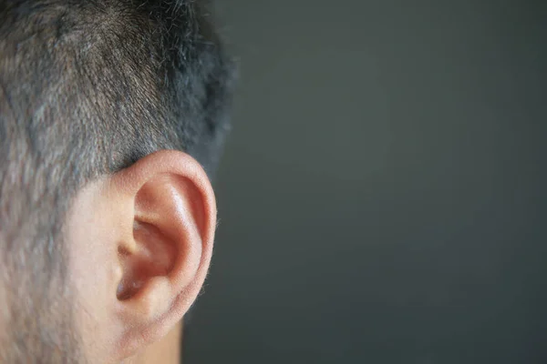 closeup of human ear on black background.