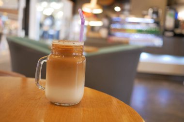 Dışarıdaki kafe masasında şeffaf bir bardakta buzlar eridi. ,