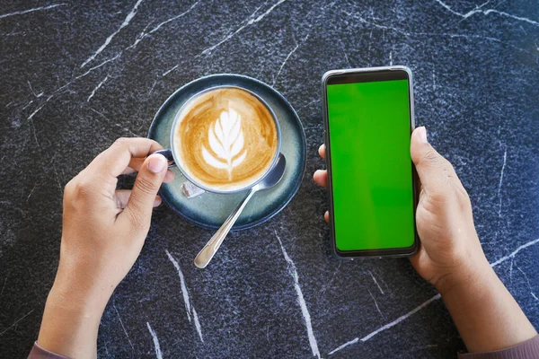 smart phone with green screen and cup of coffee on table ,