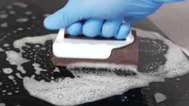 Üst Manzara Seramik elektrikli sobayı metal kazıyıcı ile temizliyor. .