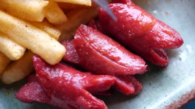 Tabakta patates kızartmasıyla servis edilen mini sosis. .