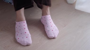 Kadınlar koltukta pembe renkli hafif çoraplar giyer. .