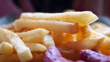  hand pick French Fries on table .