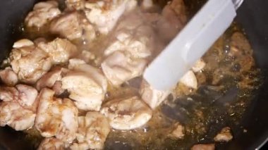 Küçük bir tavada kızarmış tavuk etine yaklaş. .