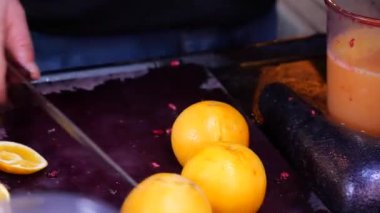 Meyve suyu yapmak için doğrama tahtasındaki portakal suyunu kesmek. .
