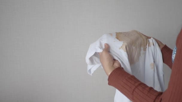 汚れを作ることを示す白い色の汚れたシャツを握っている女性 — ストック動画