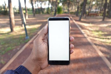 Genç adamın açık havada akıllı telefon kullanırken ki görüntüsü. ,