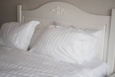 beyaz yastık yatağa dizilmiş. ,