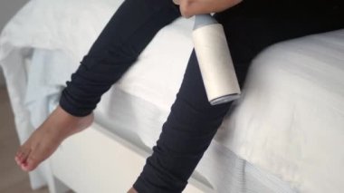 Yapışkan bir rulo kullanarak pamuğu ve pamuğu bir yataktan çıkarıyorum.