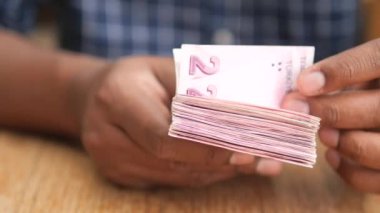 Bir adamın eli 100 dolar nakit sayıyor. .